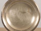 a silver plate on a stand on a table