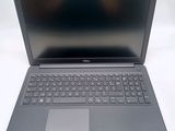 the dell laptop is sitting on a white surface with a black keyboard