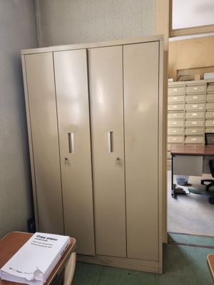 une pièce équipée d'un bureau, d'armoires et d'une chaise