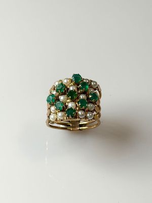 a close up of a green and white ring on a white surface