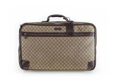 une valise marron et noire posée sur une surface blanche