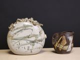 two vases sitting on a table next to each other