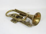 an old brass trumpet sitting on top of a white surface