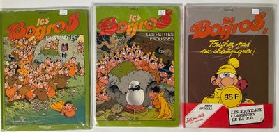 three comics are lined up on a shelf in a row