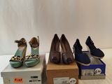 several pairs of shoes are lined up on boxes on a white surface