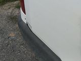 a cat sitting on the back of a white truck