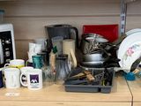 un plan de travail encombré, avec un micro-ondes, un grille-pain, des tasses et d’autres objets ménagers