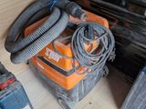 a vacuum that is sitting on the floor next to other tools