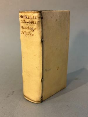 an old book sitting on top of a table next to a white wall