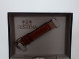 an image of a watch in a box with a red strap