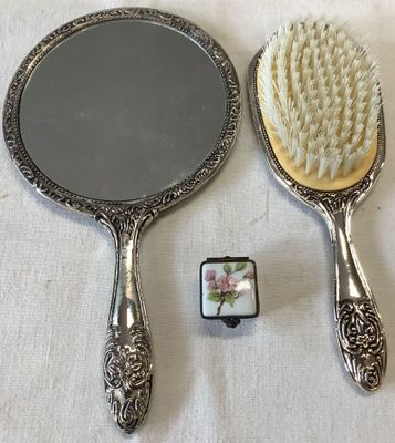 two mirrors and a brush sitting on a table