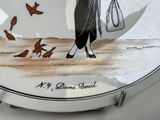 a plate with a picture of a woman and birds on it