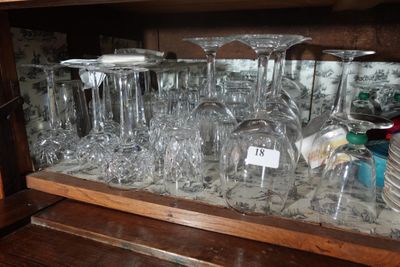 de nombreux verres à vin posés sur une étagère dans un placard