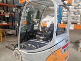 a forklift in a warehouse with pallets in the background