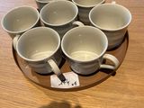 six tasses posées sur une assiette sur la table