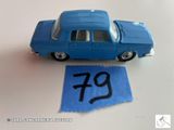 une petite voiture bleue posée sur une table, à côté d'une feuille de papier