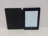 the kindle is sitting next to the black case on the table
