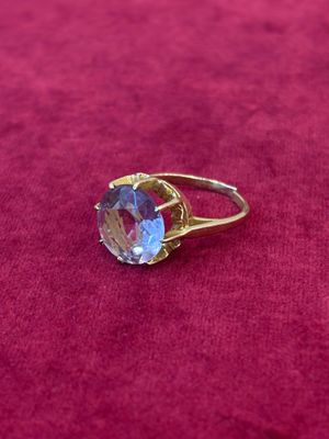 Gros plan sur une bague en or ornée d'une topaze bleue
