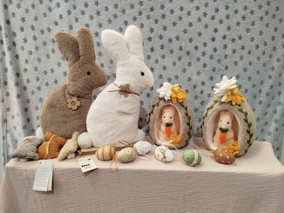 three stuffed animals sitting on a table next to other stuffed animals