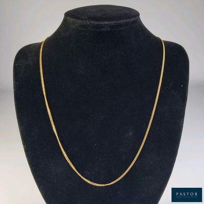 un collier à chaîne en or dans la vitrine d'un mannequin