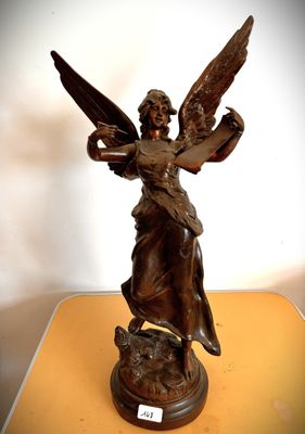 une statue représentant un ange tenant un chat sur une table
