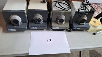 trois types différents de microscopes posés sur une table avec une feuille de papier
