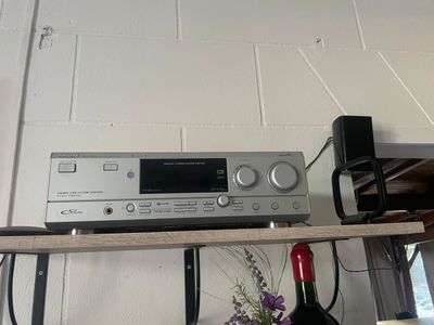 une étagère sur laquelle se trouvent une chaîne hi-fi et une bouteille de vin