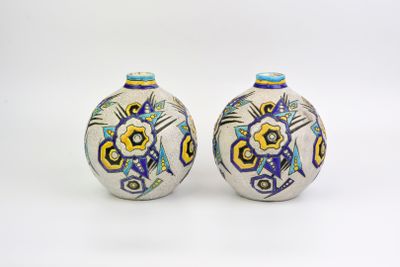 une paire de vases en céramique ornés de motifs colorés sur fond blanc