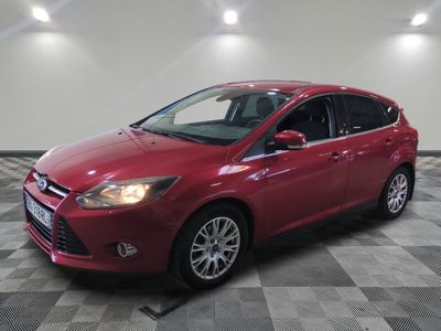Une Ford Focus rouge est garée sur un sol à damier.