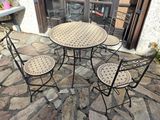 four chairs and a table on a stone patio