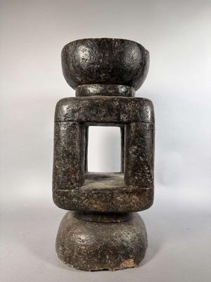 un gros plan d'une sculpture en pierre présentant un trou carré au milieu