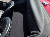 une voiture rouge équipée de sièges et d'un volant en cuir noir