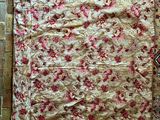un tapis posé au sol, orné d'un motif rouge et or