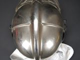 a silver helmet on a white cloth on a black surface