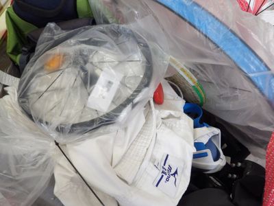 une pile de bagages dans un sac en plastique posée par terre