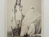 an old black and white photo of two women dressed in traditional clothing