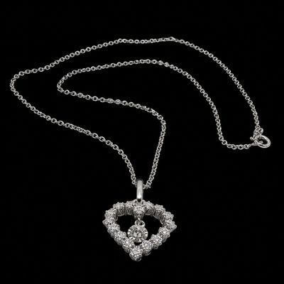 a close up of a heart shaped necklace with a chain