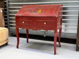 a small red desk with a drawer on top of it