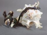 a small figurine of a lizard on top of a seashell