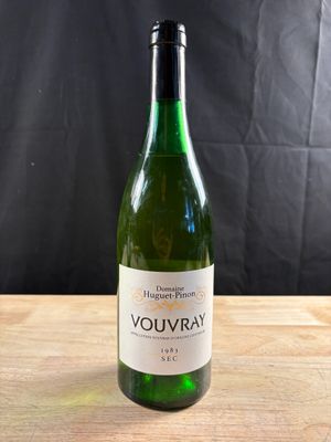 une bouteille de vin blanc posée sur une table en bois