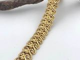 a close up of a gold chain bracelet on a branch