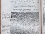 an open book on a table with a pen and ink drawing on it