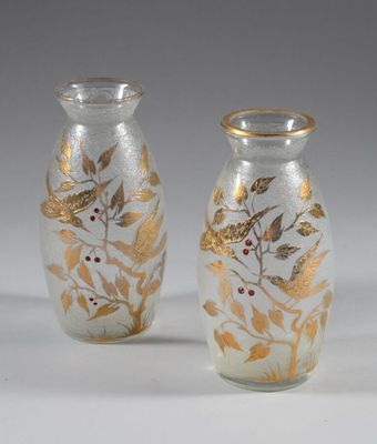 two glass vases with gold leaves and berries on them
