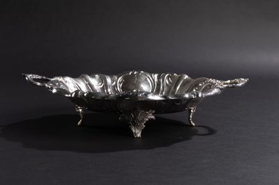 une assiette en argent ornée d'un oiseau sur fond noir