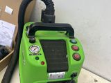 a green blow dryer sitting on the floor next to a box