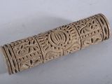 un vieux cylindre sculpté, orné d'un motif sur une surface blanche