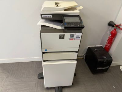 une pile d'imprimantes empilées les unes sur les autres dans une pièce