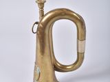 a brass trumpet that is sitting on a white surface