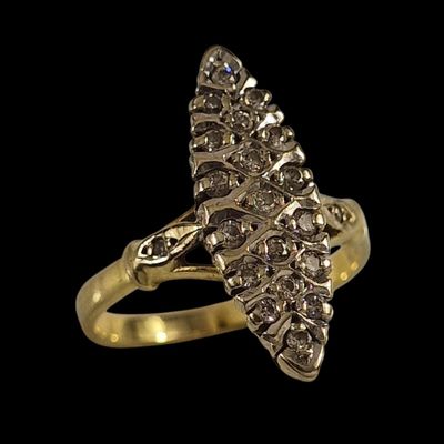 un gros plan d'une bague en or sertie de diamants sur fond noir