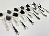 six spoons and two spoons are lined up on a white surface